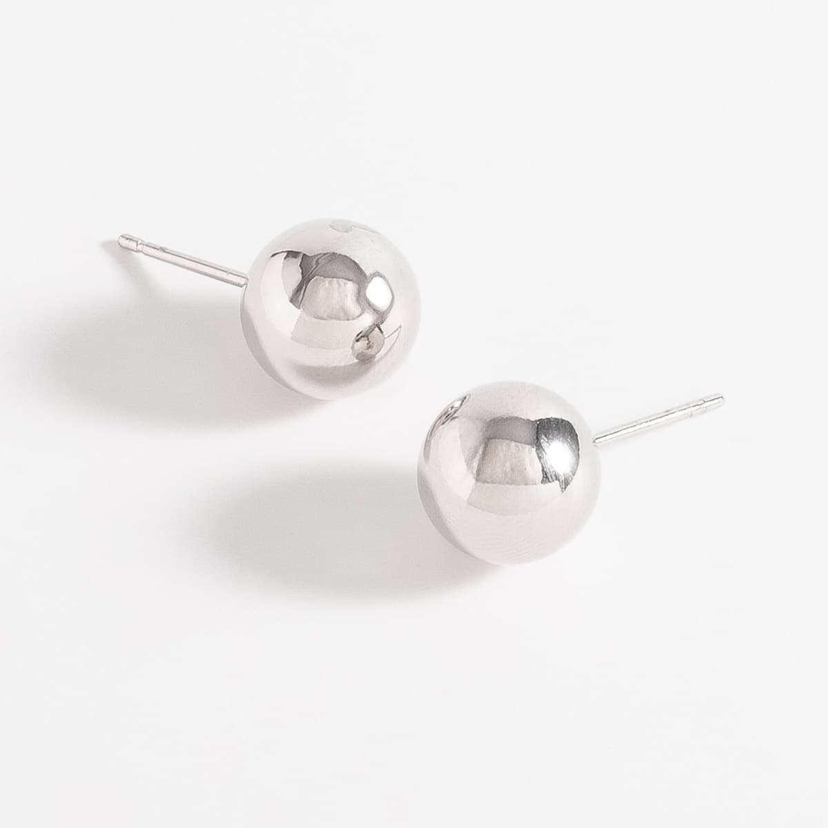 Aretes en baño de rodio diseño esfera pulida minimalista